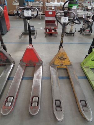 four forklifts sitting on the floor in a warehouse