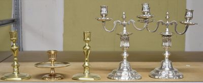 four silver candlesticks on a table next to a mirror