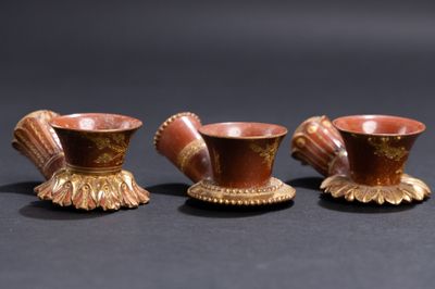 trois petits vases sont posés sur une surface noire