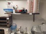 a small kitchen with a microwave, toaster, toaster and other items on the counter