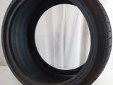 a close up of a tire on a white surface with a white curtain in the background