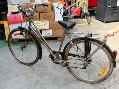 une femme debout à côté d'un vélo dans un entrepôt
