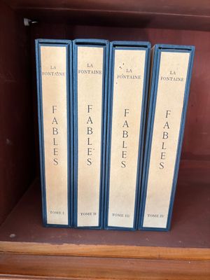three books on a shelf in a book case on a table