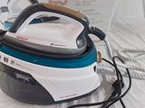 a black and white steam iron sitting on a bed