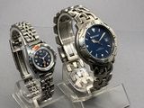 two watches that are on display on a clear stand