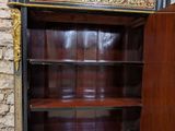 a black and gold bookcase with a clock on it