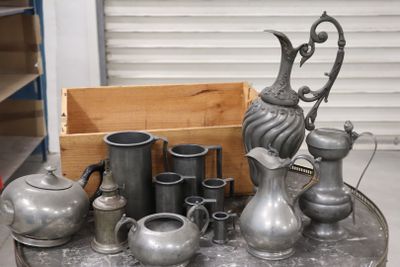 a lot of silver vases and pitchers on a table