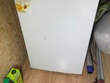 un petit réfrigérateur blanc dans le coin d'une pièce