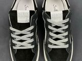 black and white sneakers with laces on them on a gray surface