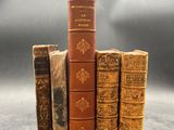 three old books stacked on top of each other on a table