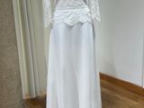 une robe blanche posée sur un présentoir à mannequin dans une pièce