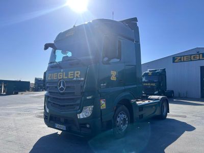 un camion vert garé devant un immeuble