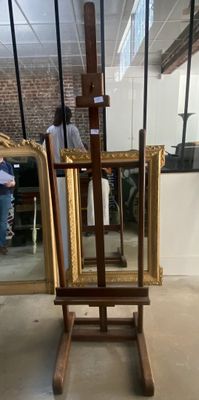 un chevalet en bois surmonté d'un miroir, dans une pièce