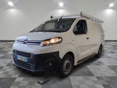 la camionnette blanche est garée dans une grande pièce au sol en damier
