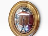 a mirror on the wall that is reflecting a person in the mirror