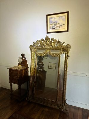 a mirror and a table in a room with a painting on the wall