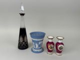 three vases and a decanter sitting on a table
