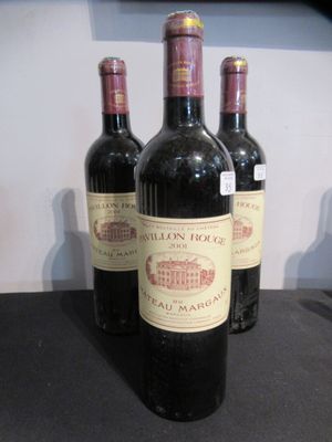 trois bouteilles de vin posées sur une table, l'une à côté de l'autre