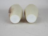 two white vases sitting on top of a white table