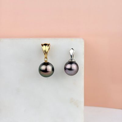 une photo d'une paire de boucles d'oreilles en perles noires posées sur une surface en marbre