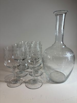 many wine glasses and a decanter sitting on a table