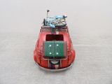 a small red car with luggage on top of it