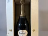 une bouteille de champagne dans un coffret en bois posée sur une table