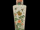 a vase that has a bird and flowers on it