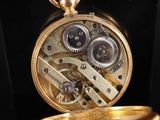 a gold pocket watch with gears inside of it