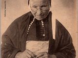 une vieille photo d'une femme en robe et coiffe