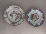 two plates with floral designs on them are sitting on a table