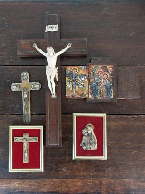 un crucifix posé sur une table en bois, avec des images de Jésus et d'autres objets religieux