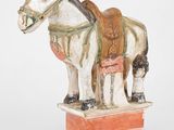 statue d'un cheval avec une selle sur le dos