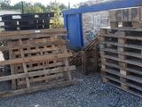 a pile of pallets sitting next to a blue container