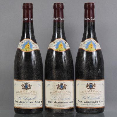 three bottles of wine are lined up on a table