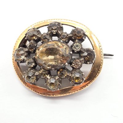 une image montrant un gros plan d'une broche ornée de cristaux sur fond blanc