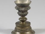 an antique silver plated candle holder with a flower design on the base