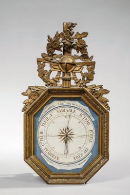 une horloge dorée avec un cadran bleu, surmontée d'un oiseau