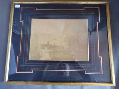 une vieille photo représentant une ville, dans un cadre doré