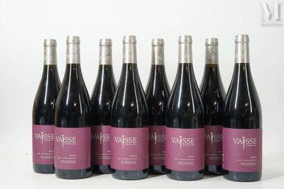 six bottles of wine are lined up in a row on a white surface