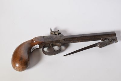 a close up of a gun and a knife on a white surface