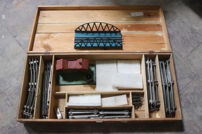 une boîte en bois remplie d'objets hétéroclites sur le sol
