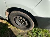 a white car with a flat tire on the side of the road