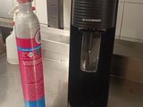 une bouteille d'eau posée à côté d'un distributeur d'eau sur le plan de travail de la cuisine