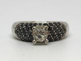 Gros plan sur une bague sertie d'un diamant et d'un diamant noir, sur fond blanc