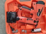 un gros plan d'une boîte orange contenant une agrafeuse à cordon et un chargeur