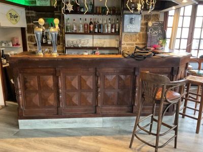 un bar en bois avec des tabourets devant
