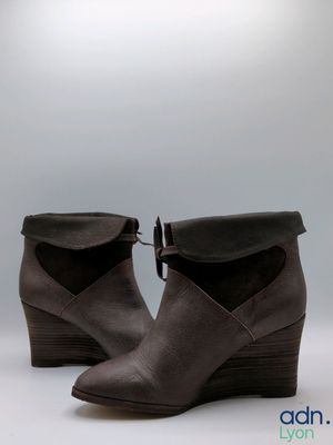 the woman is wearing a pair of brown boots with a black heel