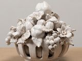 a white vase filled with lots of flowers on a table