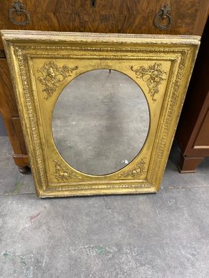 an antique gold frame with a mirror on top of it